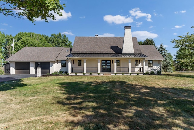 view of front of home featuring a garage, covered porch, and a front lawn