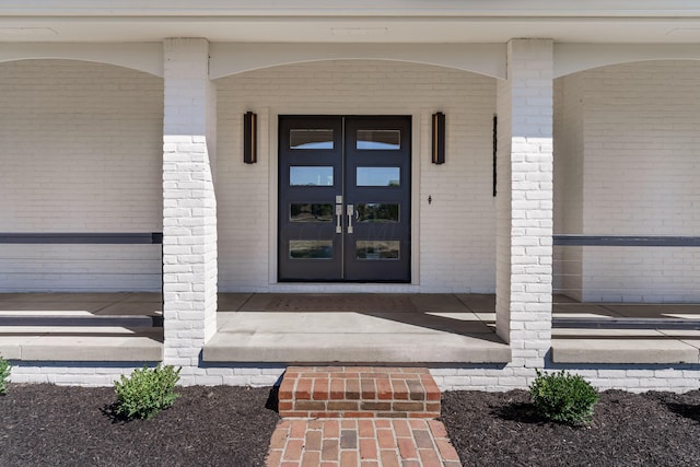 doorway to property with covered porch and french doors