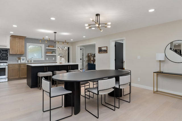 dining space with light hardwood / wood-style flooring and a notable chandelier