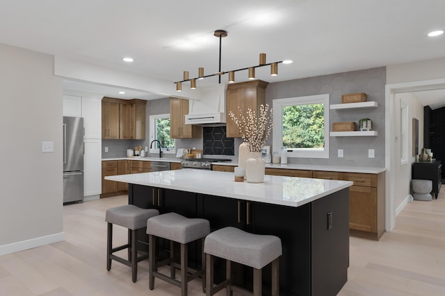 kitchen with a kitchen breakfast bar, a healthy amount of sunlight, a kitchen island, and stainless steel appliances