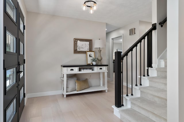 entrance foyer with light hardwood / wood-style flooring and a textured ceiling