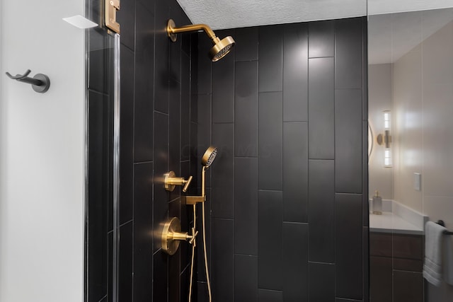 bathroom with a tile shower and a textured ceiling