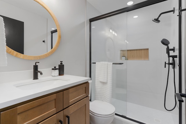 bathroom featuring toilet, vanity, and walk in shower