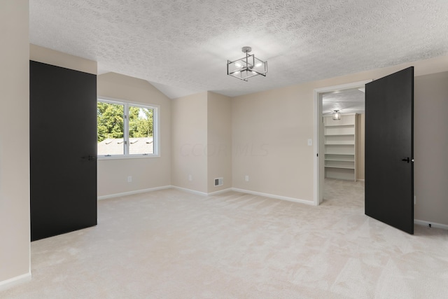 carpeted empty room featuring a textured ceiling