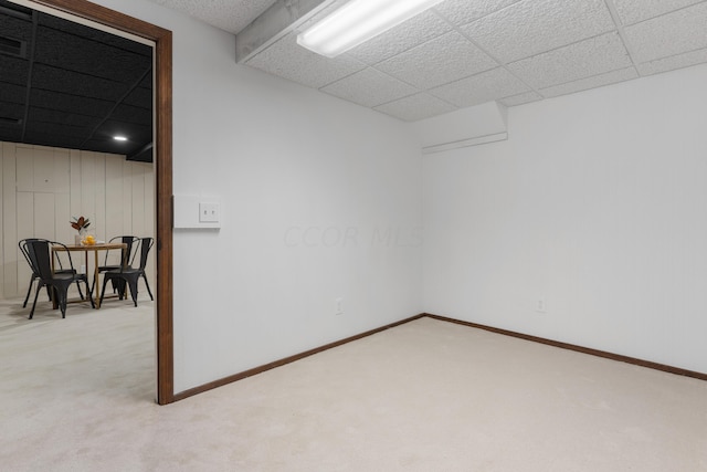 spare room featuring light carpet and a drop ceiling