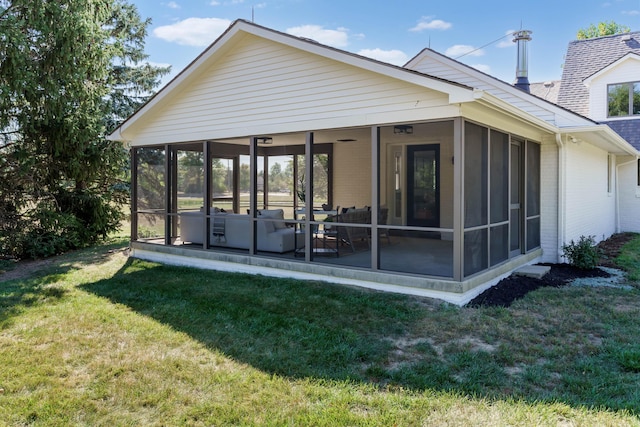 back of house with a yard and a sunroom