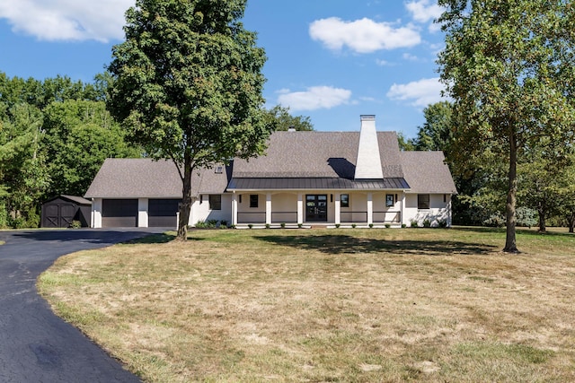 cape cod home featuring a storage unit, covered porch, and a front yard