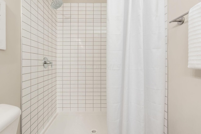 bathroom with a shower with curtain and toilet