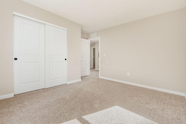 unfurnished bedroom featuring carpet flooring and a closet