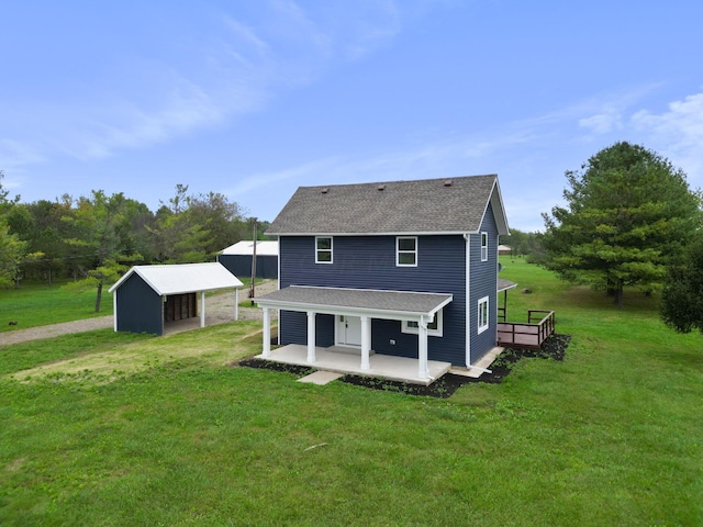 rear view of property featuring a lawn and an outdoor structure