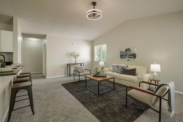 carpeted living room featuring a textured ceiling and vaulted ceiling