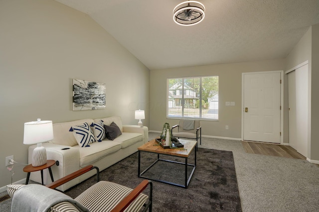 living room with wood-type flooring, a textured ceiling, and vaulted ceiling