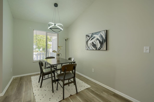 dining room featuring light hardwood / wood-style floors and lofted ceiling