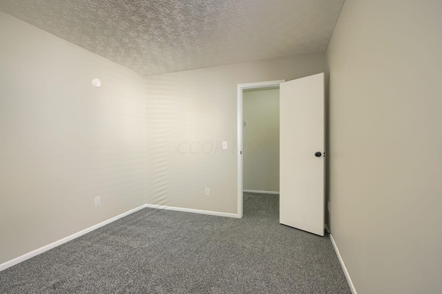 carpeted empty room featuring a textured ceiling