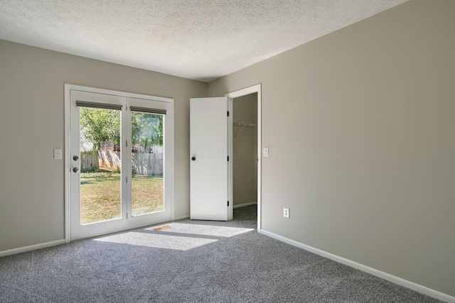 carpeted spare room with a textured ceiling