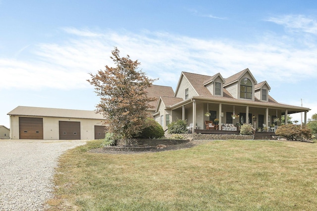 view of front facade with an outbuilding, a front lawn, covered porch, and a garage