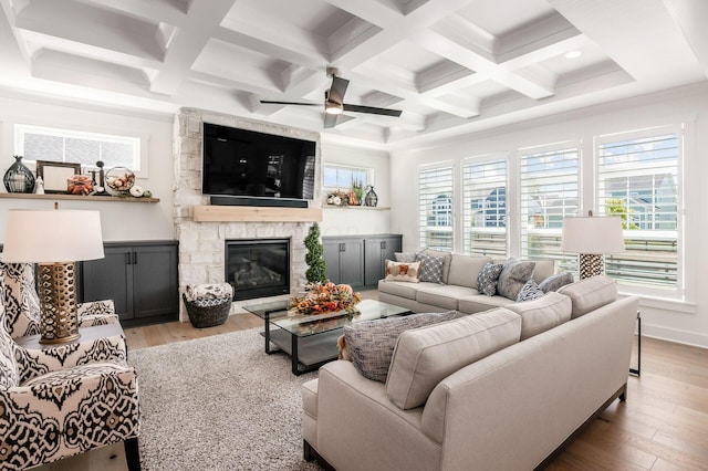 living room with beamed ceiling, a fireplace, and hardwood / wood-style floors