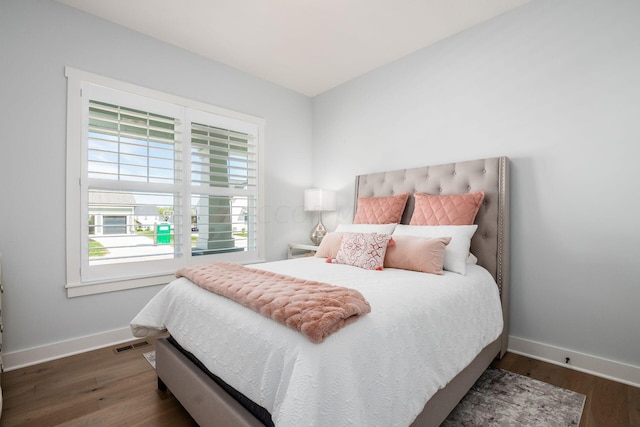 bedroom with dark hardwood / wood-style floors