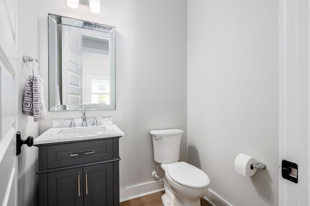 bathroom with vanity, hardwood / wood-style floors, and toilet