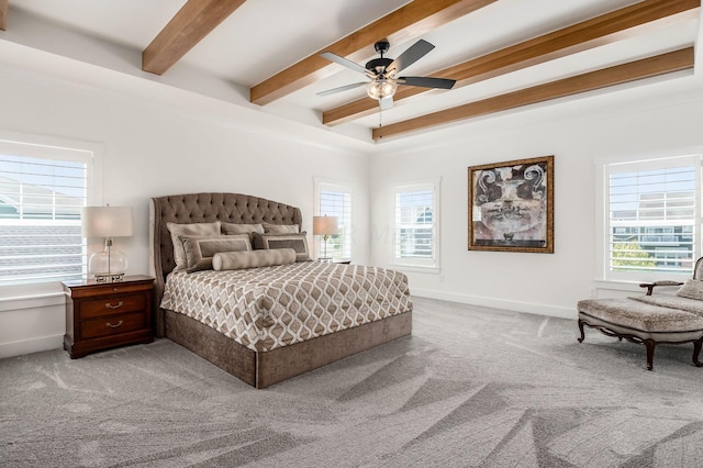 bedroom with multiple windows, carpet floors, and beamed ceiling