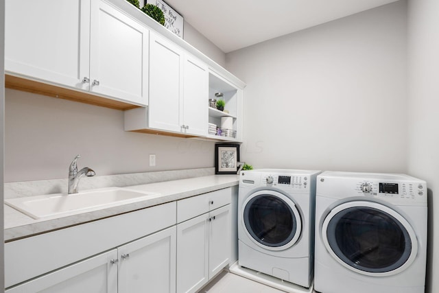 washroom with cabinets, sink, and independent washer and dryer