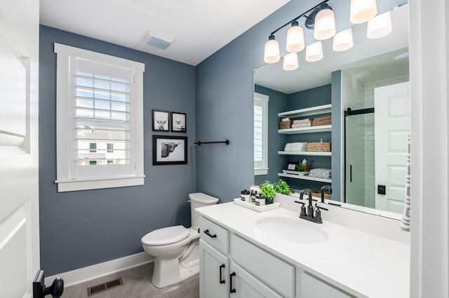 bathroom with walk in shower, vanity, and toilet