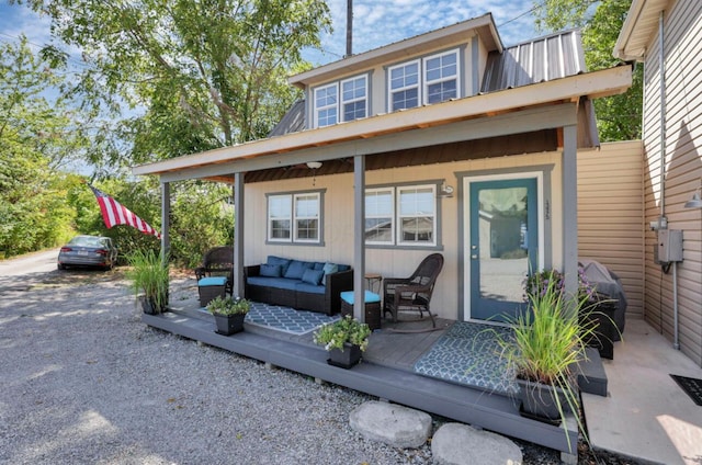 rear view of house featuring metal roof and an outdoor living space