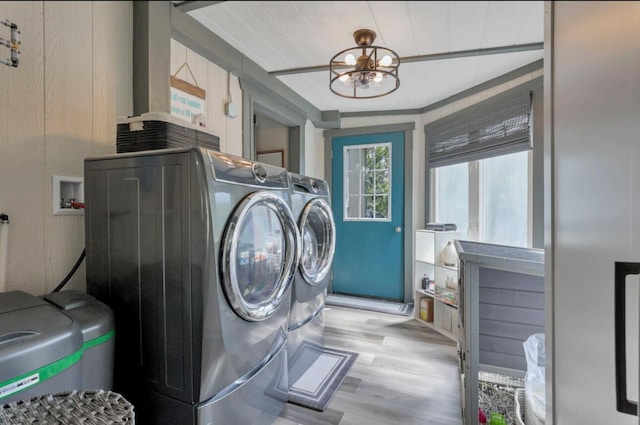 laundry room featuring a chandelier, light wood-type flooring, laundry area, and independent washer and dryer