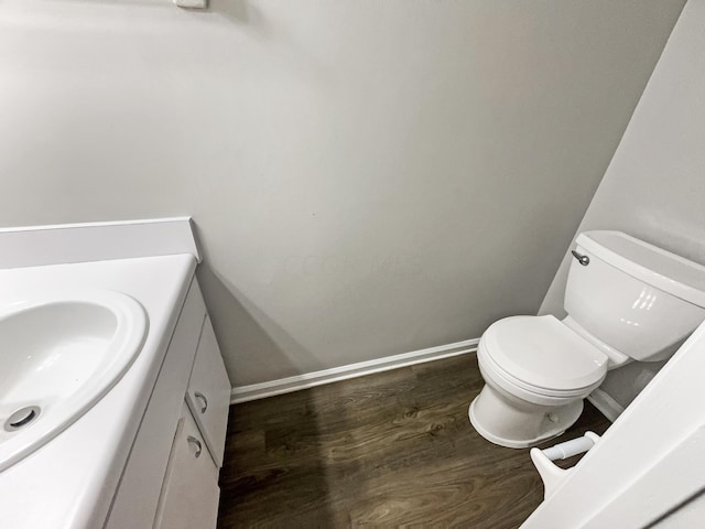 bathroom with hardwood / wood-style flooring, vanity, and toilet