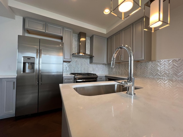 kitchen with stainless steel fridge, tasteful backsplash, wall chimney exhaust hood, decorative light fixtures, and black gas stove