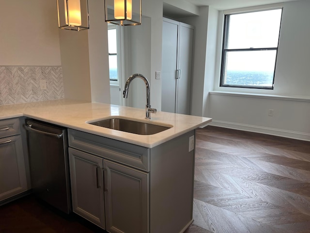 kitchen with dishwasher, backsplash, sink, decorative light fixtures, and kitchen peninsula