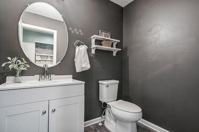 bathroom featuring wood-type flooring, vanity, and toilet