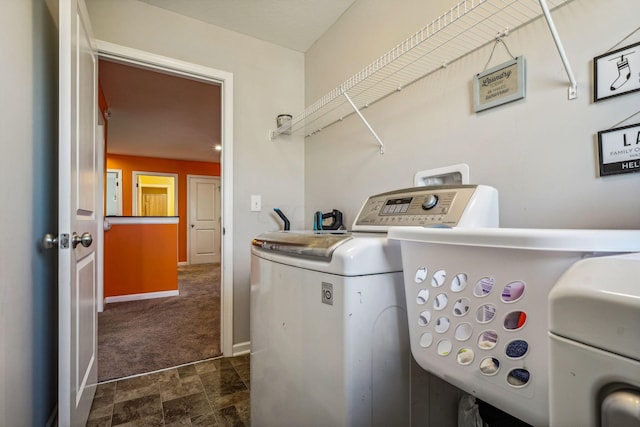 clothes washing area with separate washer and dryer and dark carpet