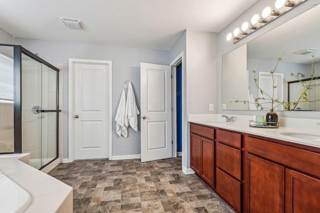 bathroom featuring a textured ceiling, vanity, and a shower with door