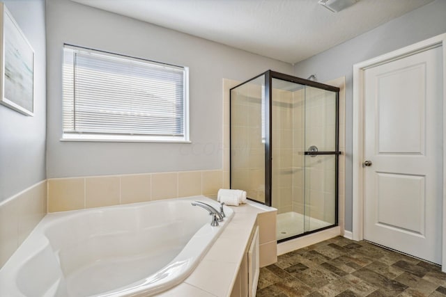 bathroom with a textured ceiling and independent shower and bath