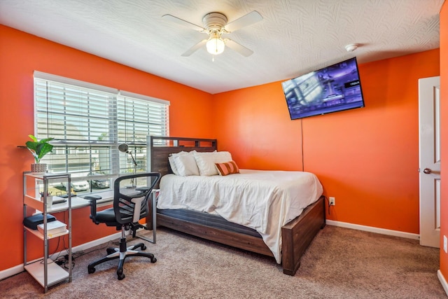 bedroom with ceiling fan, carpet, and a textured ceiling