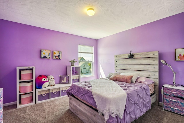 bedroom featuring dark carpet and a textured ceiling