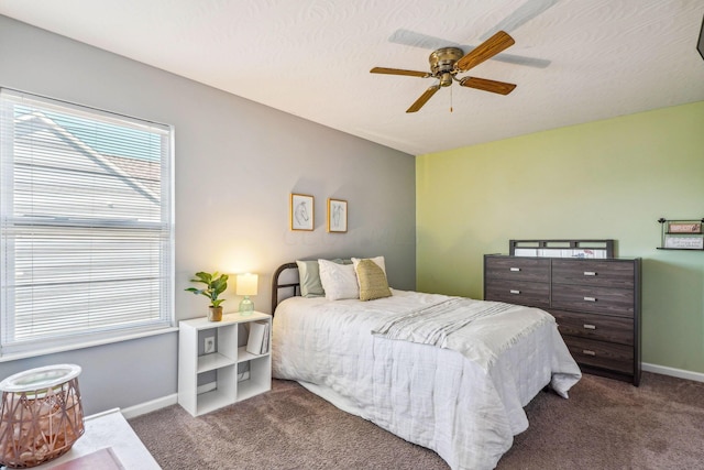 carpeted bedroom with ceiling fan and a textured ceiling