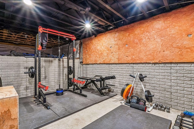 workout area featuring brick wall