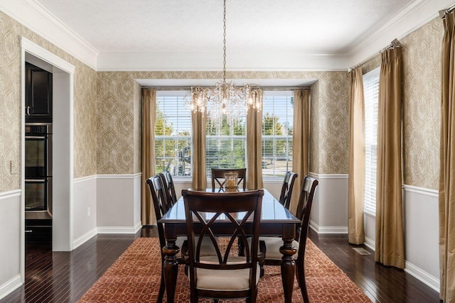 dining room featuring crown molding, dark hardwood / wood-style floors, and an inviting chandelier