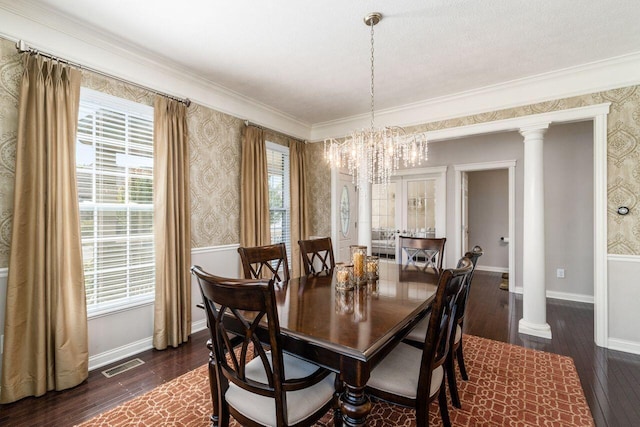 dining space featuring dark hardwood / wood-style flooring, ornate columns, crown molding, and a notable chandelier