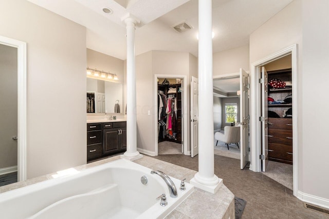 bathroom featuring a bathtub, ornate columns, a textured ceiling, and vanity