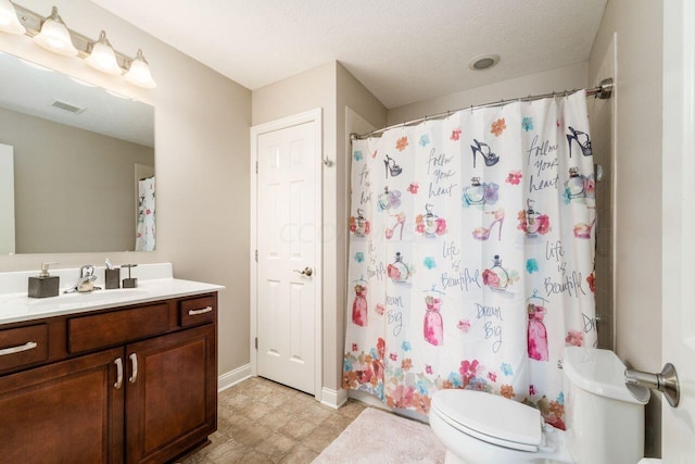 bathroom featuring a shower with curtain, vanity, toilet, and a textured ceiling