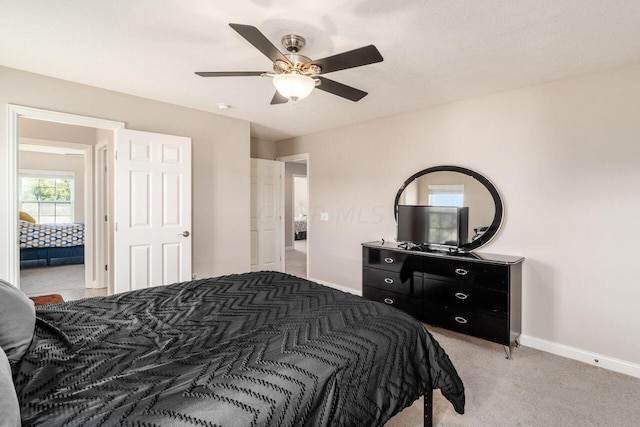 bedroom with ceiling fan and light carpet