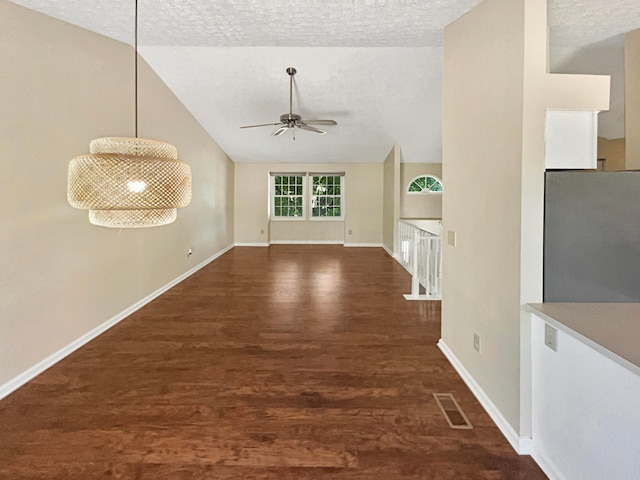 interior space featuring a textured ceiling, dark hardwood / wood-style flooring, and lofted ceiling