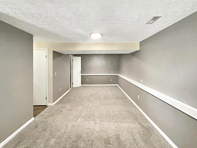 basement with carpet and a textured ceiling