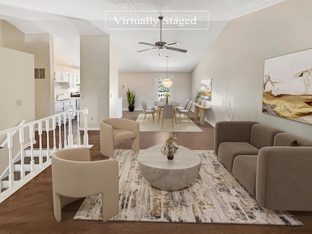 carpeted living room with a textured ceiling, vaulted ceiling, ceiling fan, and sink