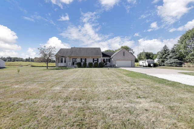 view of front of house with covered porch, a garage, and a front yard