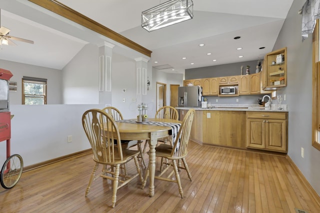 dining room featuring ceiling fan, ornate columns, lofted ceiling, and light hardwood / wood-style flooring