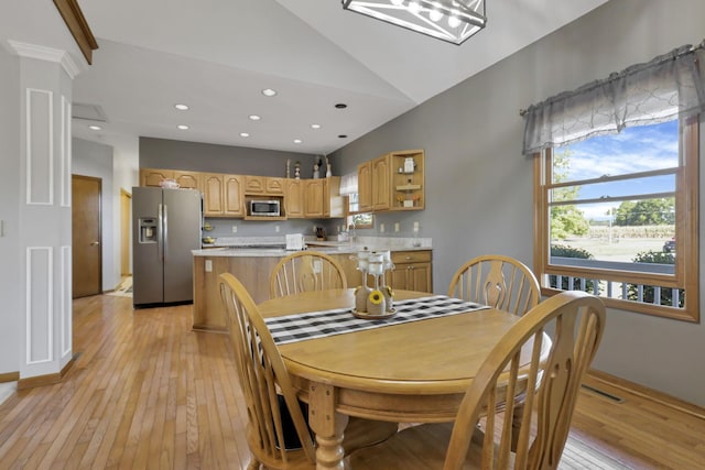 dining space featuring light hardwood / wood-style floors and lofted ceiling